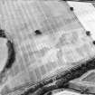 Oblique aerial view centred on the cropmarks of the pit-defined enclosure and field boundary, taken from the ENE.