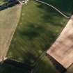 Oblique aerial view centred on the crop marks of the settlement, with the crop marks of the enclosure and rig adjacent, taken from the ESE.