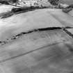 Oblique aerial view centred on the soilmarks of the fort, taken from the SE.