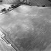 Oblique aerial view of West Morriston centred on the cropmarks of a fort, taken from the WNW.