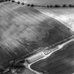 Oblique aerial view centred on the cropmarks of the fort, taken from the NNE.