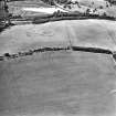 Oblique aerial view centred on the parchmarks of the fort, taken from the E.