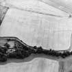 Oblique aerial view centred on the cropmarks of the airship sheds and adjacent circular features, the farmsteading and dovecot, taken from the NNW.