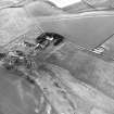 Whitelaw, oblique aerial view, taken from the ESE, centred on the cropmarks of an enclosure adjacent to a farmhouse and farmsteading.