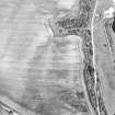 Oblique aerial view of Easter Broomhouse centred on the cropmark of a fort.  Taken from the WSW.