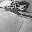 Oblique aerial view centred on the cropmarks of the settlement with the country house adjacent, taken from the WNW.