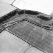 Oblique aerial view centred on the cropmarks of the fort, taken from the NE.