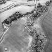 Oblique aerial view centred on the cropmarks of the enclosure with dovecot adjacent, taken from the S.