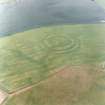 Oblique aerial view centred on the cropmarks of the fort with field boundaries and  cropmarks adjacent, taken from the WSW.