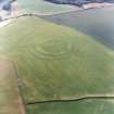 Oblique aerial view centred on the cropmarks of the fort with field boundaries and  cropmarks adjacent, taken from the SSE.