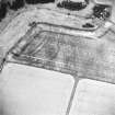 Oblique aerial view centred on the cropmarks of the fort, taken from the NE.