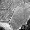Oblique aerial view centred on the cropmarks of the field boundaries and cropmarks with fort adjacent, taken from the W.