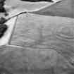 Oblique aerial view centred on the cropmarks of the field boundaries and cropmarks with fort adjacent, taken from the S.