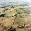General oblique aerial view looking NW over the line of Deer Street Roman road, quarry pits, rig and enclosure towards Cessford Moor, taken from the SE.