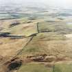 General oblique aerial view looking NW over the line of Deer Street Roman road, quarry pits, rig and enclosure towards Cessford Moor, taken from the ESE.
