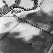 Oblique aerial view of Eckford Mill centred on the cropmarks of an enclosure with pit-circle and other pits with a bridge and grain mill adjacent, taken from the W.