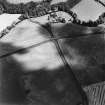 Oblique aerial view of Eckford Mill centred on the cropmarks of an enclosure with pit-circle and other pits with a bridge and grain mill adjacent, taken from the SW.