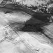 Oblique aerial view centred on the remains of the fort and settlement with fort adjacent, taken from the WSW.