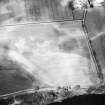 Oblique aerial view centred on the cropmarks of the enclosure, taken from the SSE.