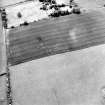 Oblique aerial view centred on the cropmarks of the settlement with coach house and stable adjacent, taken from the ENE.