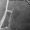 Skateraw, oblique aerial view, taken from the WNW, centred on cropmarks including an  enclosure and ring-ditch. Further cropmarks are visible in the left half of the photograph.