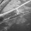 Skateraw, oblique aerial view, taken from the SW, centred on the cropmarks of an enclosure, and an area with ring-ditches, a pit-circle and possible cists is visible in the top left-hand corner. Reinforced flasks from the Torness Powerstation being loaded are shown in the centre of the photograph.