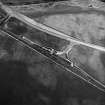 Skateraw, oblique aerial view, taken from the SSW, centred on the cropmarks of an enclosure, and an area with ring-ditches, a pit-circle and possible cists is visible in the top right-hand corner. Reinforced flasks from the Torness Powerstation being loaded are shown in the centre of the photograph.