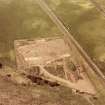 Oblique aerial view showing the excavation of a palisaded enclosure.
