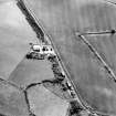 Oblique aerial view centred on the cropmarks of the settlement with the cropmarks of a settlement and field boundary adjacent, taken from the NE.