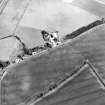 Oblique aerial view centred on the cropmarks of the settlement with the cropmarks of a settlement and field boundary adjacent, taken from the NW.