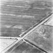 East Reston, oblique aerial view taken from the SW, centred on the cropmark of a barrow.  In the top left hand corner of the photograph the faint traces of cropmarks of ring-ditches are visible.