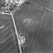 Oblique aerial view centred on the cropmarks of the possible enclosure with country house adjacent, taken from the NNW.