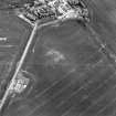 Oblique aerial view centred on the cropmarks of the possible enclosure with country house adjacent, taken from the NW.