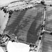 Oblique aerial view centred on the cropmarks of the barrow and unenclosed settlement, taken from the NNE.