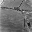 Innermessan, oblique aerial view, taken from the SW, showing the cropmarks of a settlement, round houses, a possible enclosure and a pair of linear cropmarks.
