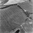 Innermessan, oblique aerial view, taken from the SE, showing the cropmarks of a settlement, round houses, a possible enclosure and a pair of linear cropmarks.