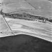 Beach Cottage, oblique aerial view, taken from the NW, showing linear cropmarks and cultivation remains, and the remains of Cairnryan Military Railway.