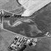 Garleffin, oblique aerial view, taken from the ESE, centred on the cropmarks of a four poster stone-circle, ring-ditches, a barrow and pits. An area with a possible souterrain, enclosures and cropmarks is visible in the right half of the photograph.