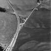 Ballantrae Bridge, oblique aerial view, taken from the NW, centred on the cropmarks of a possible souterrain and a round house. An area with pits and field boundaries are also shown in the photograph.