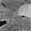 Soulseat Loch-Kirminnoch, oblique aerial view, taken from the S, showing the cropmarks of a roman road and relating quarry pits.