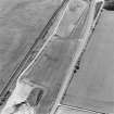 Oblique aerial photograph of Drumflower taken from the E, centred on the cropmarks of barrows, pits and a pit-alignment with the line of a military road to the N.