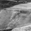 Oblique aerial view centred on the cropmarks of the pit-circle, pit-setting, possible enclosures, field boundary, linear cropmarks and pits, taken from the E.