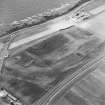 Oblique aerial view centred on the cropmarks of the fort, ring-ditch and possible quarry, taken from the SE.