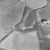 Oblique aerial view centred on the cropmarks of the enclosure and pits with settlement adjacent, taken from the ESE.