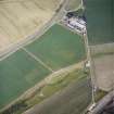 Oblique aerial view centred on the cropmarks of the fort with the farmsteading adjacent, taken from the NNW.