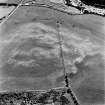 Shalloch Hill, Girvan, oblique aerial view, taken from the NW, centred on the cropmarks of a palisaded settlement and linear cropmarks.