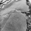 Oblique aerial view centred on the parchmarks of the palisaded settlement with quarries and field boundaries adjacent, taken from the NE.