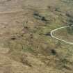 Oblique aerial view centred on the remains of the field-system and small cairns with hut-circle and small cairns adjacent, taken from the NW.