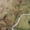 Oblique aerial view centred on the remains of the farmstead, field-system, rig and small cairns, taken from the WSW.