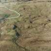 Oblique aerial view centred on the remains of the hut-circle, small cairns and field system with farmstead, field-system, rig and small cairns adjacent, taken from the E.